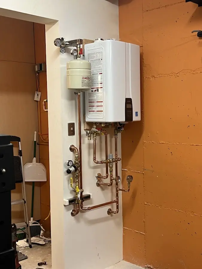 Plumbing technician inspecting water heater connections in Fort Walton Beach